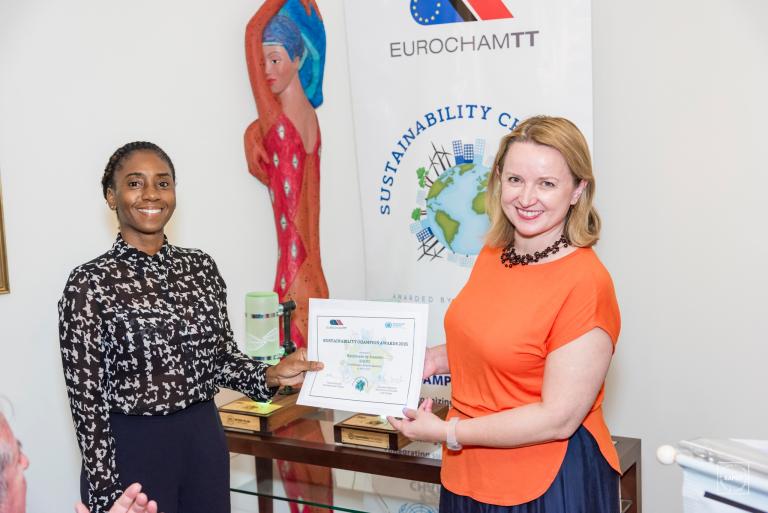 UN Resident Coordinator hands out a certificate of achievement to a sustainable business